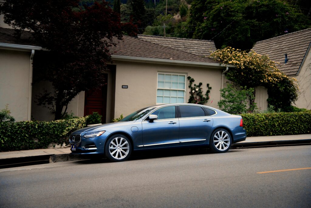 Blue car parked in front of a house