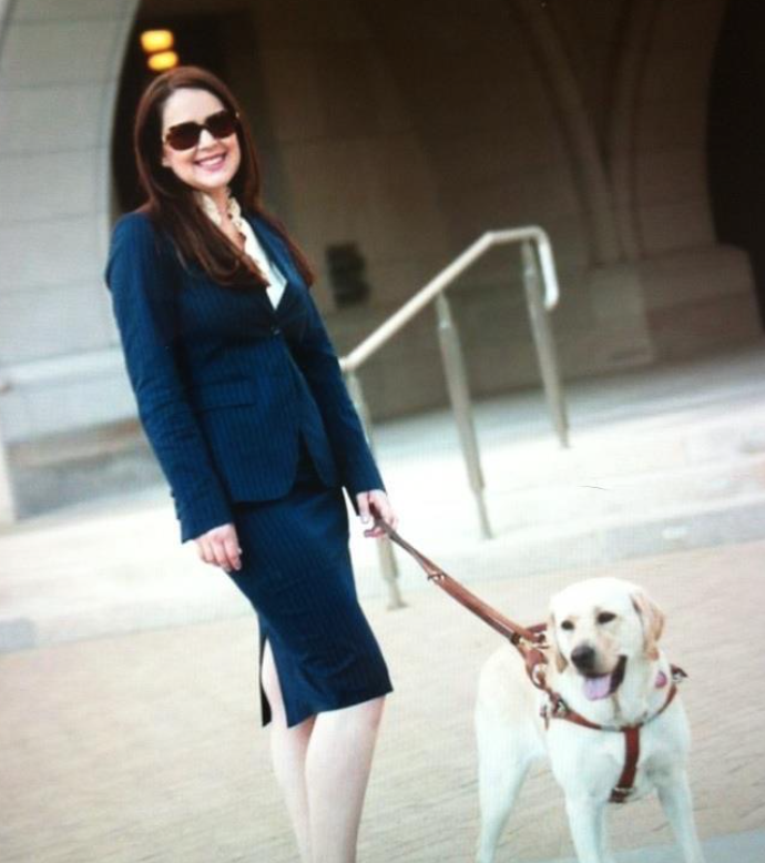kristin Fleschner walking her dog leashed, wearing blue suit