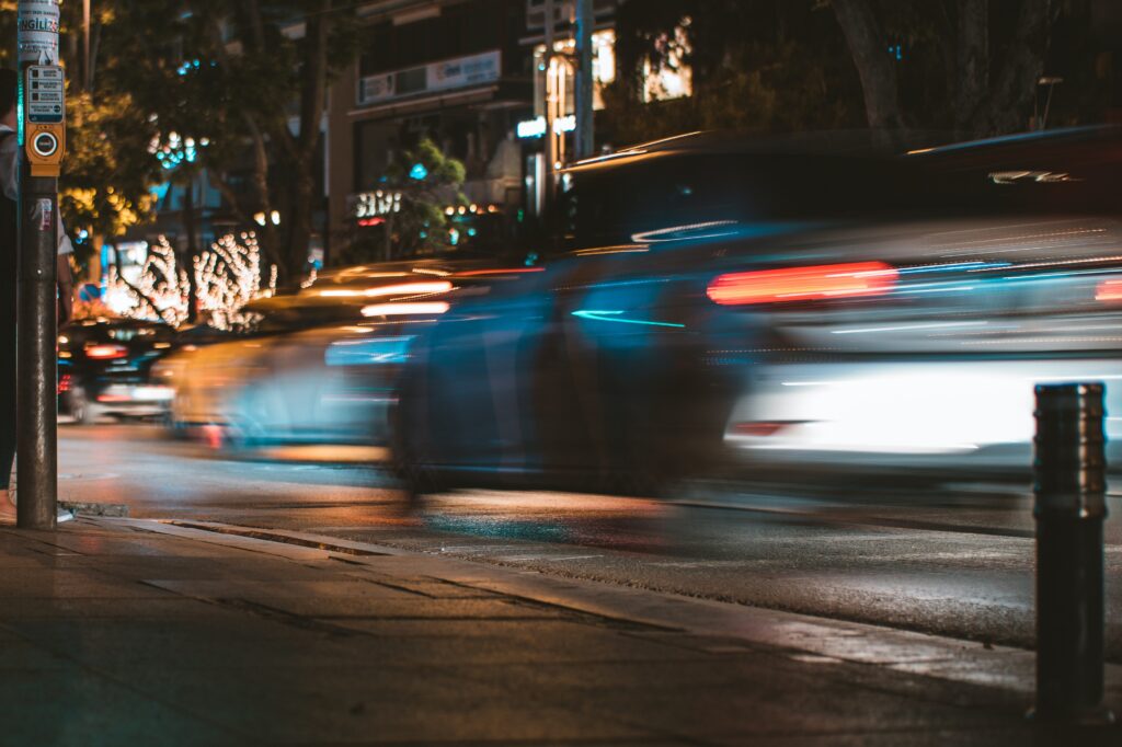 A shot of cars zooming past on a busy street.