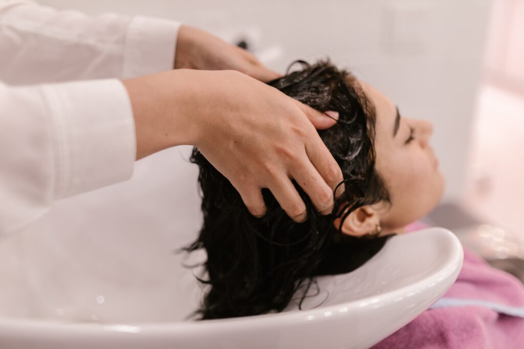 A Woman Having Her Hair Washed on a Salon Sink