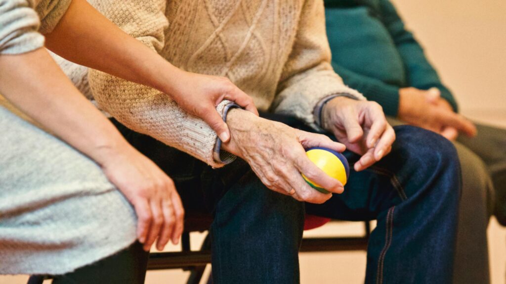 Individual holding an elderly person's wrist