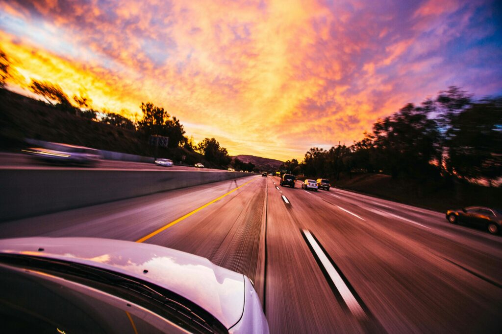 Car driving down the highway at sunset