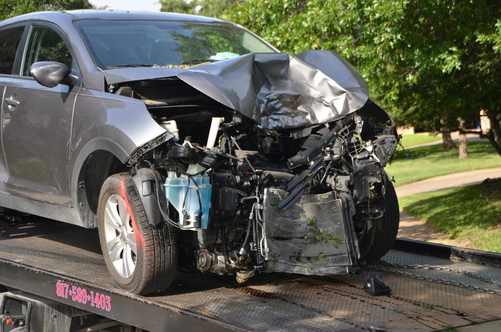 Car with crumpled front bumper on truck bed