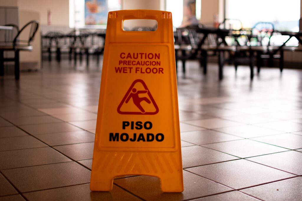 Yellow wet floor sign set up on restaurant floor