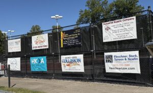 Signs of companies sponsoring Rose-Hulman tennis teams attached to court fence